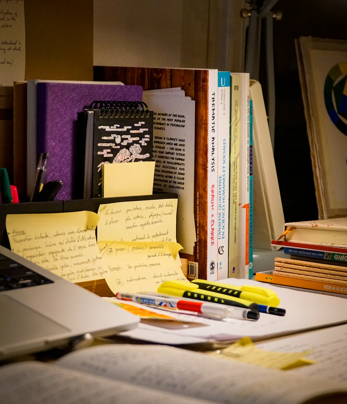 Open study books, laptop and notes on a desk